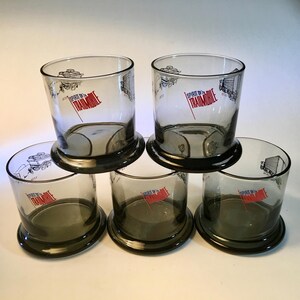 Set of five vintage Spirit of 76 Trailmobile bicentennial short glasses with wide bases featuring transportation trailers from 1776 and 1976