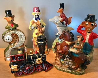 Puede incluir: Colección de botellas de licor de cerámica vintage con diseños únicos. Las botellas presentan figuras de animales y personajes, incluyendo un zorro, un payaso y un conejo, con un tren y una figura montada a caballo. Las botellas son de varios colores.