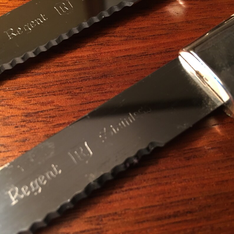 Set of four Regent Stainless steak knives with silver inlays