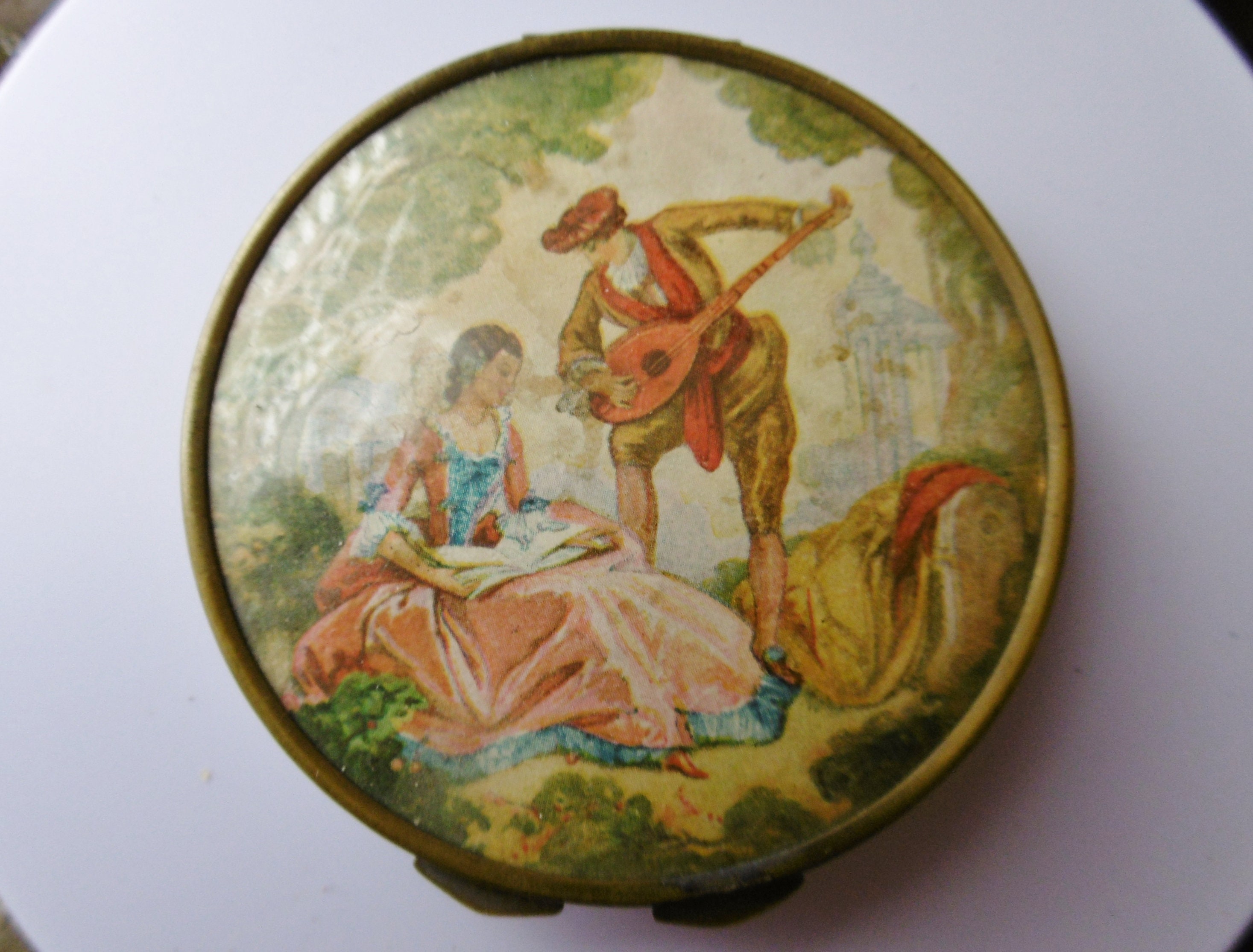 Vintage French brass compact with Romantic scene.
