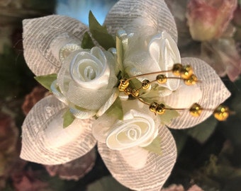 May include: A white flower made of fabric with gold beads and wire accents. The flower is made of multiple layers of fabric and has a delicate, feminine look.