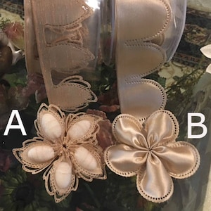 Puede incluir: Dos flores de tela beige con bordes festoneados. La flor de la izquierda es un diseño más intrincado con una textura de encaje. La flor de la derecha es un diseño simple y liso.