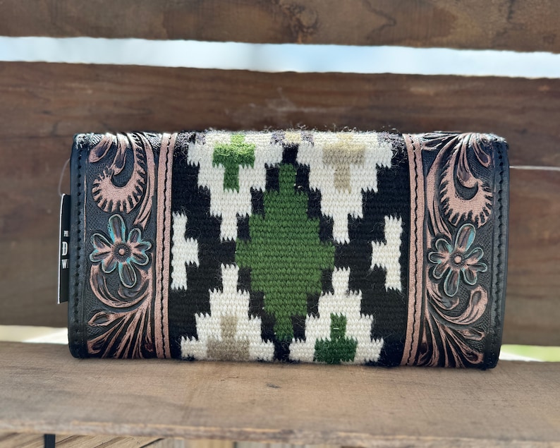 May include: Black leather wallet with a geometric pattern in white, green, and brown. The wallet has a floral design embossed on the sides.