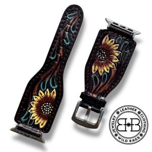 Puede incluir: Correa de reloj de cuero marr&oacute;n de dos piezas con dise&ntilde;o de girasol. La correa presenta un girasol en relieve detallado con p&eacute;talos amarillos y marrones y un centro blanco. Acentos turquesa y marr&oacute;n rodean la flor. Hebilla y conectores plateados.