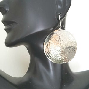 May include: Silver hammered circle earrings with a textured surface.