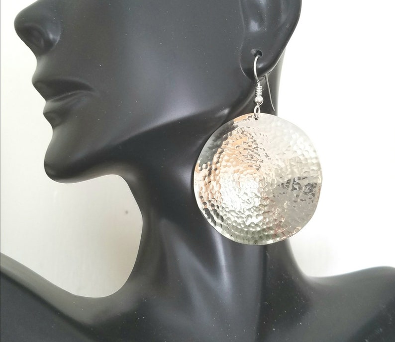 May include: Silver hammered circle earrings with a textured surface.