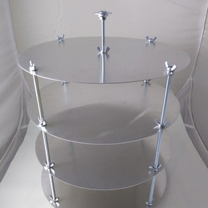 May include: A silver cake stand with four tiers and adjustable height. The stand is made of metal and has a smooth, polished finish.