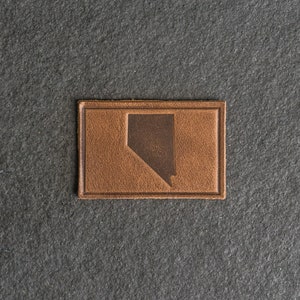Op de afbeelding: Een bruin leren patch met de omtrek van de staat Nevada.
