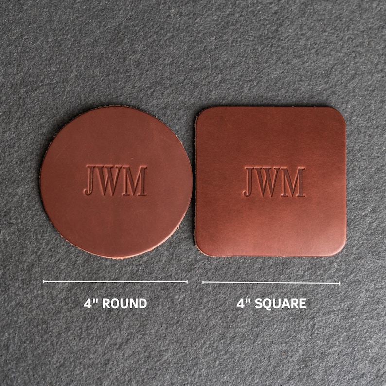 May include: Two leather coasters with the initials "JWM" embossed on them. The coaster on the left is round and measures 4 inches in diameter. The coaster on the right is square and measures 4 inches on each side.