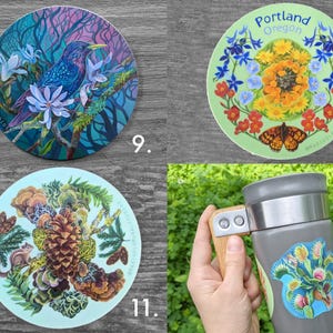 May include: A collection of round stickers and a travel mug. The stickers feature colorful illustrations of a bird, flowers, a butterfly, and a pinecone. The travel mug is gray with a wooden handle and a sticker of a Venus flytrap.