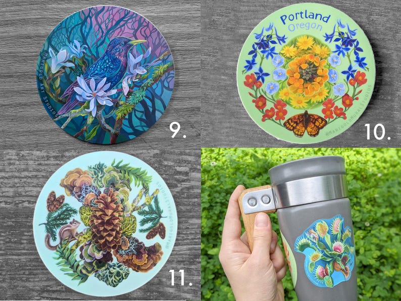 May include: A collection of round stickers and a travel mug. The stickers feature colorful illustrations of a bird, flowers, a butterfly, and a pinecone. The travel mug is gray with a wooden handle and a sticker of a Venus flytrap.