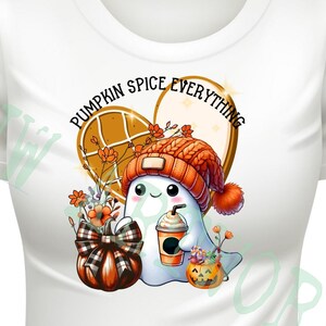 Może przedstawiać: Biała koszulka z uroczym duchem w pomarańczowej czapce na drutach, trzymającym latte z przyprawą dyniową. Duch otoczony jest jesiennymi ozdobami, w tym dynią, kwiatami i sercowatym gofrem z napisem "Pumpkin Spice Everything".