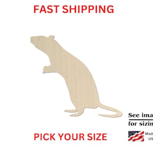 May include: Wooden cutout of a rat in a standing position. The rat is facing to the left. The cutout is made of light brown wood.