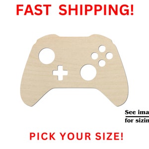 May include: A wooden cutout of a video game controller. The controller is light brown and has a white outline of the buttons. The text "Pick Your Size!" is below the controller.
