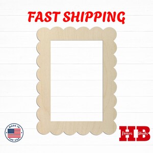 May include: A rectangular wooden frame cutout featuring a scalloped edge design. The frame is light beige in color with a smooth, flat surface and a large rectangular opening in the center. The object is presented as a blank craft piece.