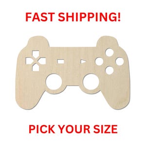 May include: A light-colored wooden cutout shaped like a video game controller. The design features cut-out symbols including a cross, a square, a triangle, and a circle, along with two circular openings for joysticks. The text reads FAST SHIPPING! PICK YOUR SIZE.