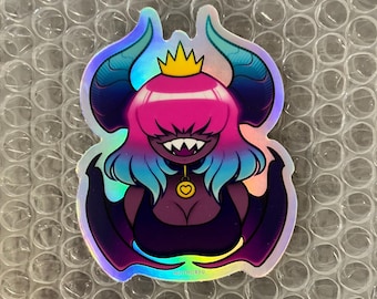 May include: A holographic sticker featuring a pink and blue demon with a crown, wings, and a heart-shaped collar. The sticker has a glossy finish and is perfect for adding a touch of whimsy to any surface.