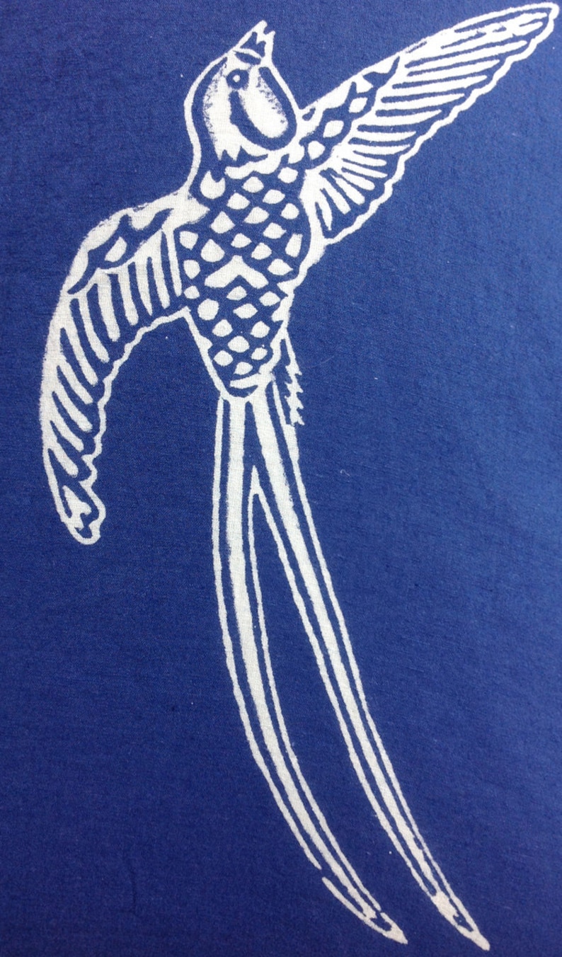 May include: White bird illustration on a blue background. The bird is depicted with outstretched wings and long, flowing tail feathers. The design has a vintage, hand-drawn aesthetic, with detailed patterns on the bird's body.
