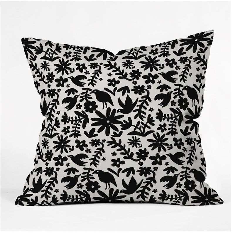 May include: A black and white throw pillow with a floral and bird pattern. The pillow is made of a soft, comfortable fabric and features a unique design.
