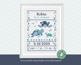 May include: Framed cross-stitch art featuring three turtles in shades of blue and teal, with the name "Robin" and birth details. The text "Do it yourself customizable cross stitch pattern" is at the bottom. The frame is white.