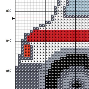 May include: Cross stitch pattern with a black and white design of a dog's head with a red and white stripe across the forehead. The pattern is on a white grid.