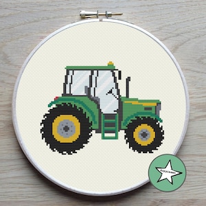 Può includere: Modello di punto croce di trattore verde e giallo in un cerchio da ricamo bianco.