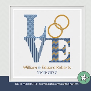 Puede incluir: Patrón de punto de cruz para "LOVE" en un esquema de colores azul y dorado. Las letras están decoradas con diferentes patrones. Dos anillos dorados están por encima de las letras. El texto debajo de las letras dice "William & Eduard Roberts 10-10-2022".