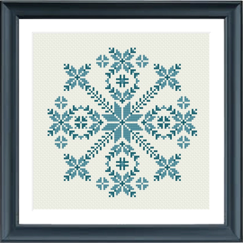May include: Framed cross-stitch artwork featuring a symmetrical teal and light blue floral design on an off-white background. The design includes star-like shapes, floral motifs, and geometric patterns. The artwork is enclosed in a dark blue frame.