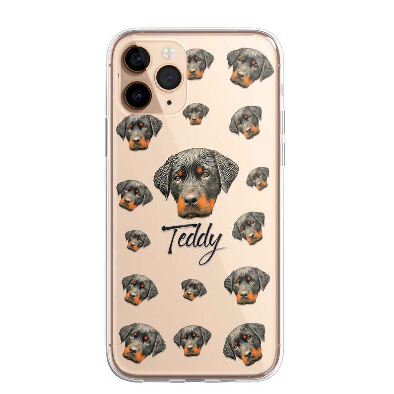 May include: A clear phone case with a pattern of Rottweiler dog faces. The case has a gold background and the name "Teddy" is written in black cursive.