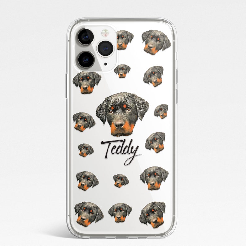 May include: Clear phone case with a repeating pattern of Rottweiler dog faces. The text "Teddy" is printed in black cursive on the case.
