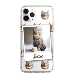 K&ouml;nnte beinhalten: Eine transparente Handyh&uuml;lle mit wei&szlig;em Hintergrund und einem sich wiederholenden Muster aus dem Gesicht einer gestromten Katze. Ein gr&ouml;&szlig;eres Bild einer gestromten Katze, die mit einem Wollkn&auml;uel sitzt, befindet sich in der Mitte der H&uuml;lle. Das Bild ist mit einem wei&szlig;en Rahmen versehen und das Wort "Jessie" steht unter dem Bild.