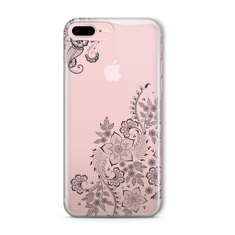 Op de afbeelding: Een transparante telefoonhoes met een zwart bloemenontwerp. Het ontwerp bevat ingewikkelde swirls en bladeren.