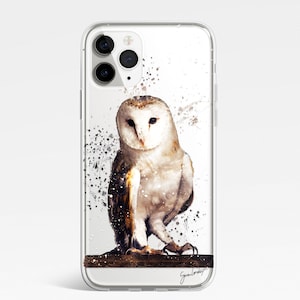 May include: Clear phone case featuring a watercolor painting of a barn owl. The owl has white and brown feathers and is perched on a branch. Splatter art in black and brown surrounds the owl. The artist's signature is at the bottom.