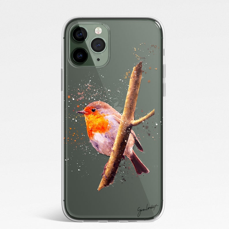 May include: Clear phone case featuring a watercolor painting of a robin perched on a branch. The bird has a vibrant orange breast and is set against a muted green background with paint splatter details. The case has a glossy finish.