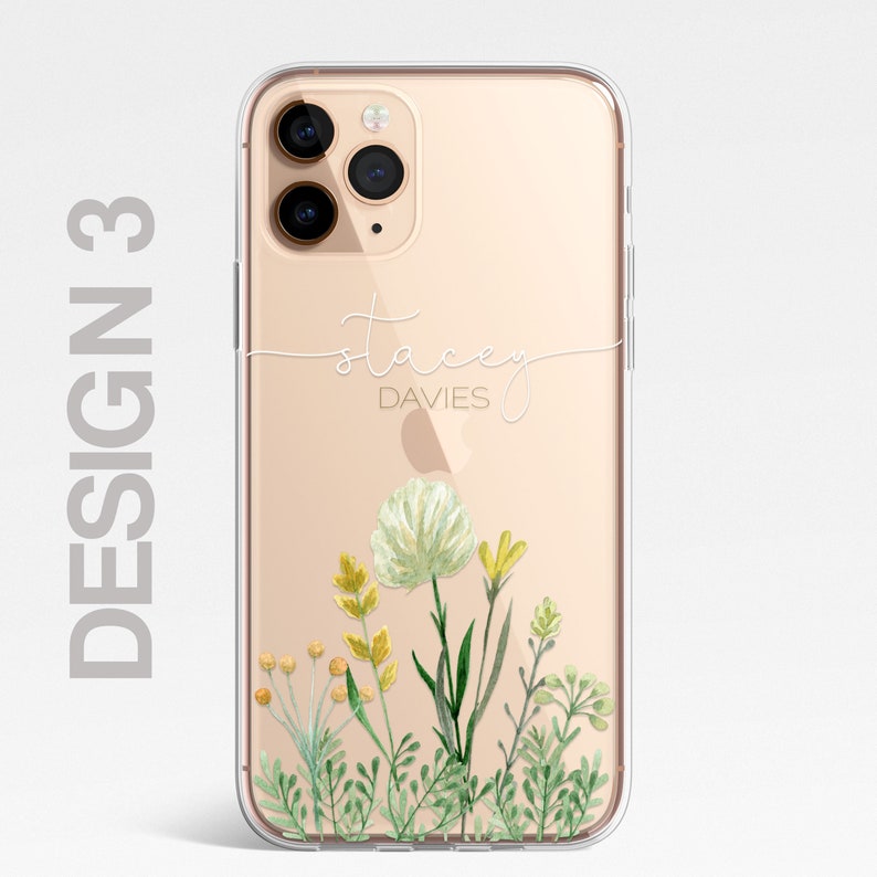 Op de afbeelding: Een transparante telefoonhoes met een gouden achtergrond en een bloemenontwerp. De hoes heeft de naam "Stacey Davies" in wit cursief erop geschreven.