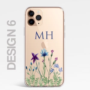 Op de afbeelding: Een transparante telefoonhoes met een gouden achtergrond en een bloemenontwerp. De hoes heeft een blauw en paars bloemenontwerp met groene bladeren. De initialen "MH" zijn in blauw op de hoes gedrukt.