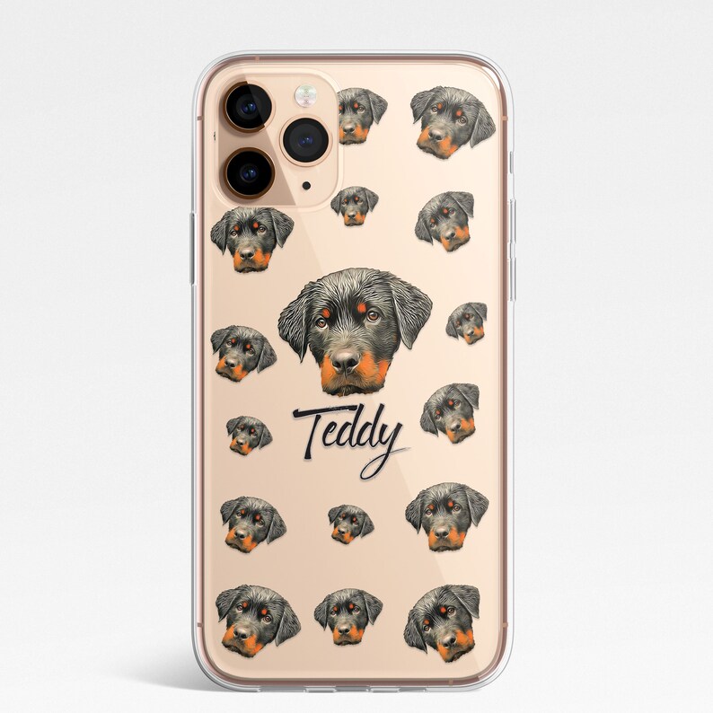 May include: A clear phone case with a pattern of Rottweiler dog faces. The case has a gold background and the name "Teddy" is written in black cursive.