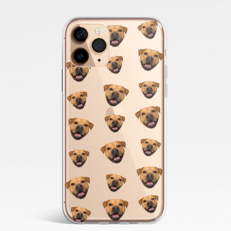 May include: A clear phone case with a repeating pattern of a brown dog's face. The case is designed for an iPhone with a triple lens camera.