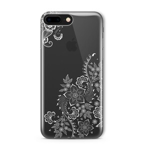 Op de afbeelding: Een transparante telefoonhoes met een wit bloemenontwerp. Het ontwerp bevat ingewikkelde swirls en bladeren.