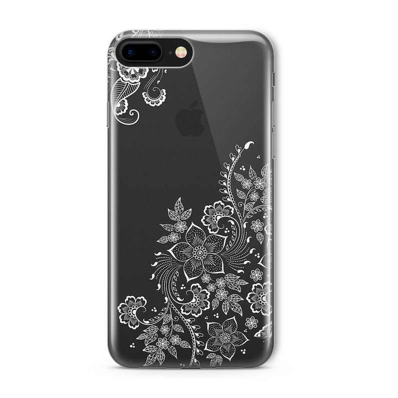 Op de afbeelding: Een transparante telefoonhoes met een wit bloemenontwerp. Het ontwerp bevat ingewikkelde swirls en bladeren.