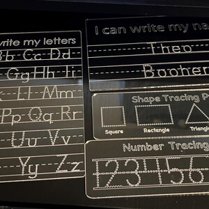 May include: Clear acrylic learning boards for writing practice. Includes boards for letters, name, shapes, and numbers. The text "I can write my letters", "I can write my name", "Shape Tracing Practice", and "Number Tracing Practice" are visible.
