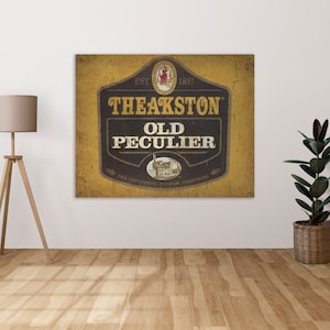 Puede incluir: Un letrero de estilo vintage con fondo amarillo y letras negras. El letrero dice "EST. 1827 Theakston Old Peculier Theakston, Masham, Yorkshire".