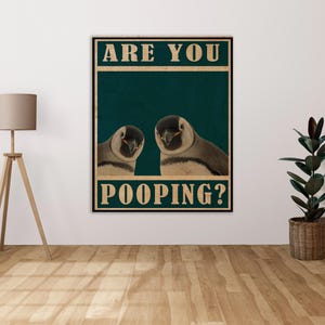 Puede incluir: Un póster de estilo vintage con dos pingüinos mirando al espectador. El póster tiene el texto "Are you pooping?" en una fuente blanca en negrita.