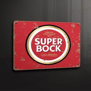 Puede incluir: Un letrero de metal rojo y dorado con las palabras "Super Bock" en un círculo. El letrero también dice "Produto de Portugal 1927" y "Sabor Autentico".
