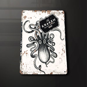 Puede incluir: Un letrero de metal blanco con un aspecto desgastado y envejecido. El letrero presenta una ilustración en blanco y negro de un pulpo con el texto "The Kraken Black Spiced Rum" en un óvalo negro.