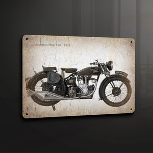 Puede incluir: Una motocicleta Velocette MAC 350 negra vintage de 1938. La motocicleta tiene un tubo de escape cromado y un asiento de cuero marrón.