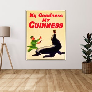 Puede incluir: Póster vintage que anuncia la cerveza Guinness. El póster presenta una foca de dibujos animados con un vaso de Guinness en la cabeza y un hombre con un uniforme verde que sostiene una botella de Guinness.