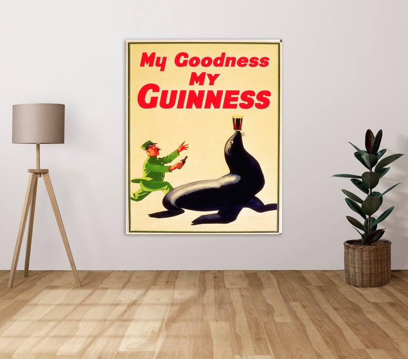 Pu&ograve; includere: Poster vintage per la birra Guinness. Il poster presenta una foca di cartone animato con un bicchiere di Guinness sulla testa e un uomo in uniforme verde che tiene una bottiglia di Guinness.