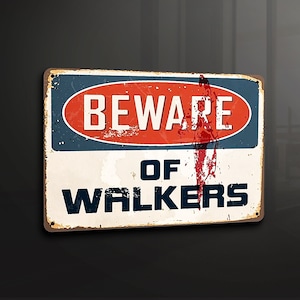 Puede incluir: Un letrero metálico rectangular con un acabado envejecido. El letrero presenta las palabras "BEWARE OF WALKERS" en texto blanco sobre un fondo rojo y azul. El letrero tiene una apariencia vintage y desgastada.