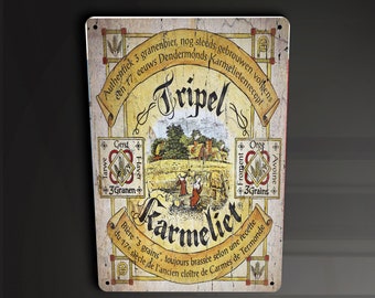 May include: A vintage-style metal sign advertising a Belgian Tripel beer called "Karmeliet." The sign features a detailed illustration of a medieval monastery and the text "Authentiek 3 granenbier, nog steeds gebrouwen een 17 eeuws Dendermonds Karmelietenrecept."  The sign also includes the text "Bière "3 grains, toujours brassée selon une recette du 17e siècle de l'ancien cloître de Carmes de Termonde."